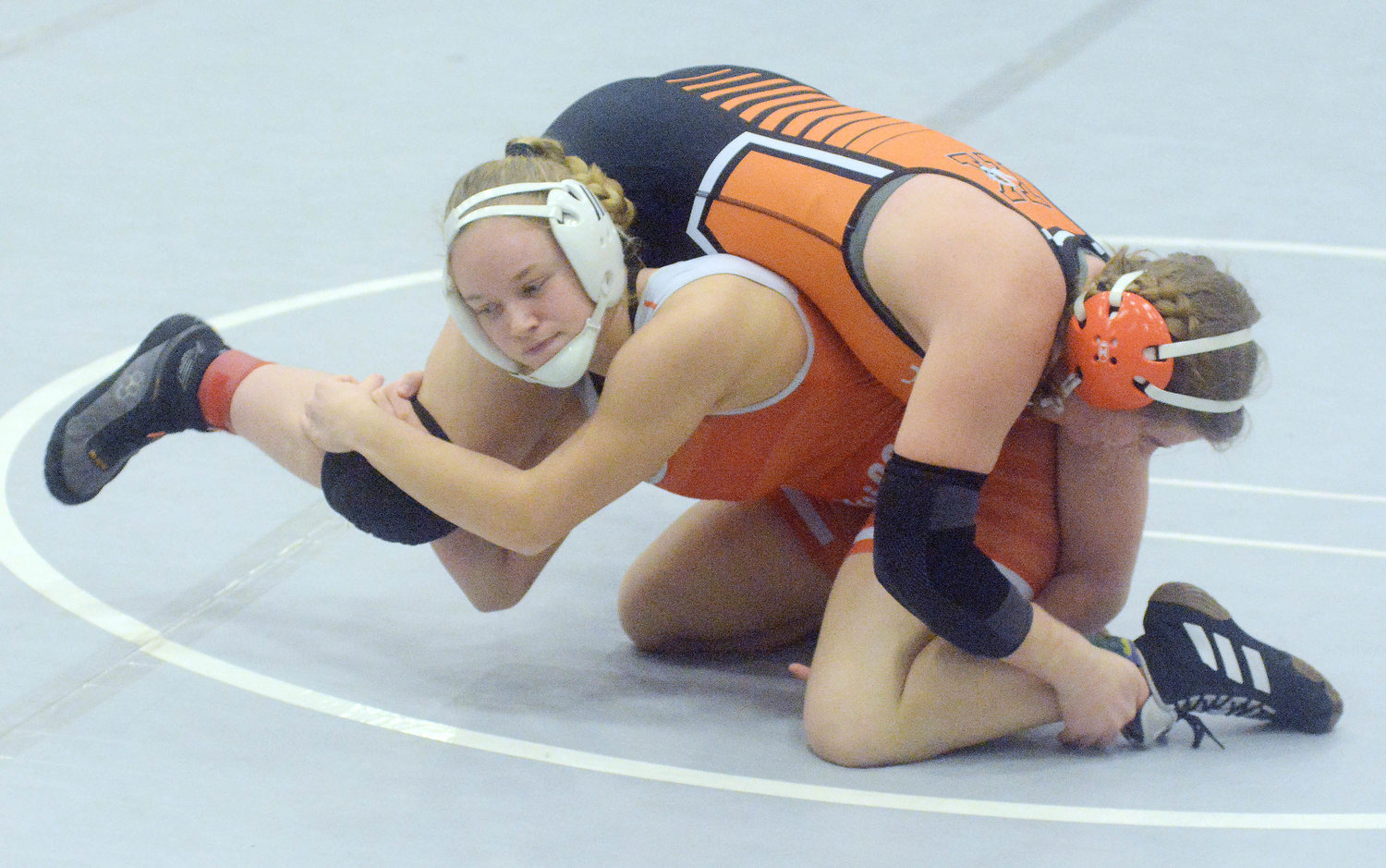 Bailee Dare (left) grabs the leg of Kirksville’s Madisynn Crawford during their round three showdown Thursday at the Wonder Woman Wrestling Tournament in Columbia on the Battle High School campus.